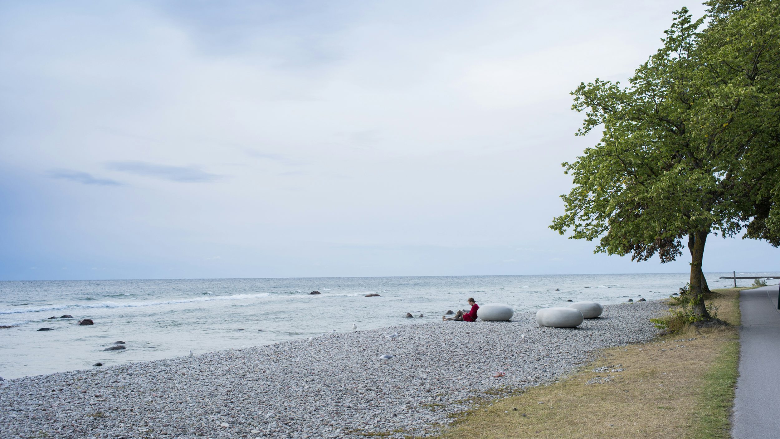 person i medeltidskläder kopplar av på strandpromenaden