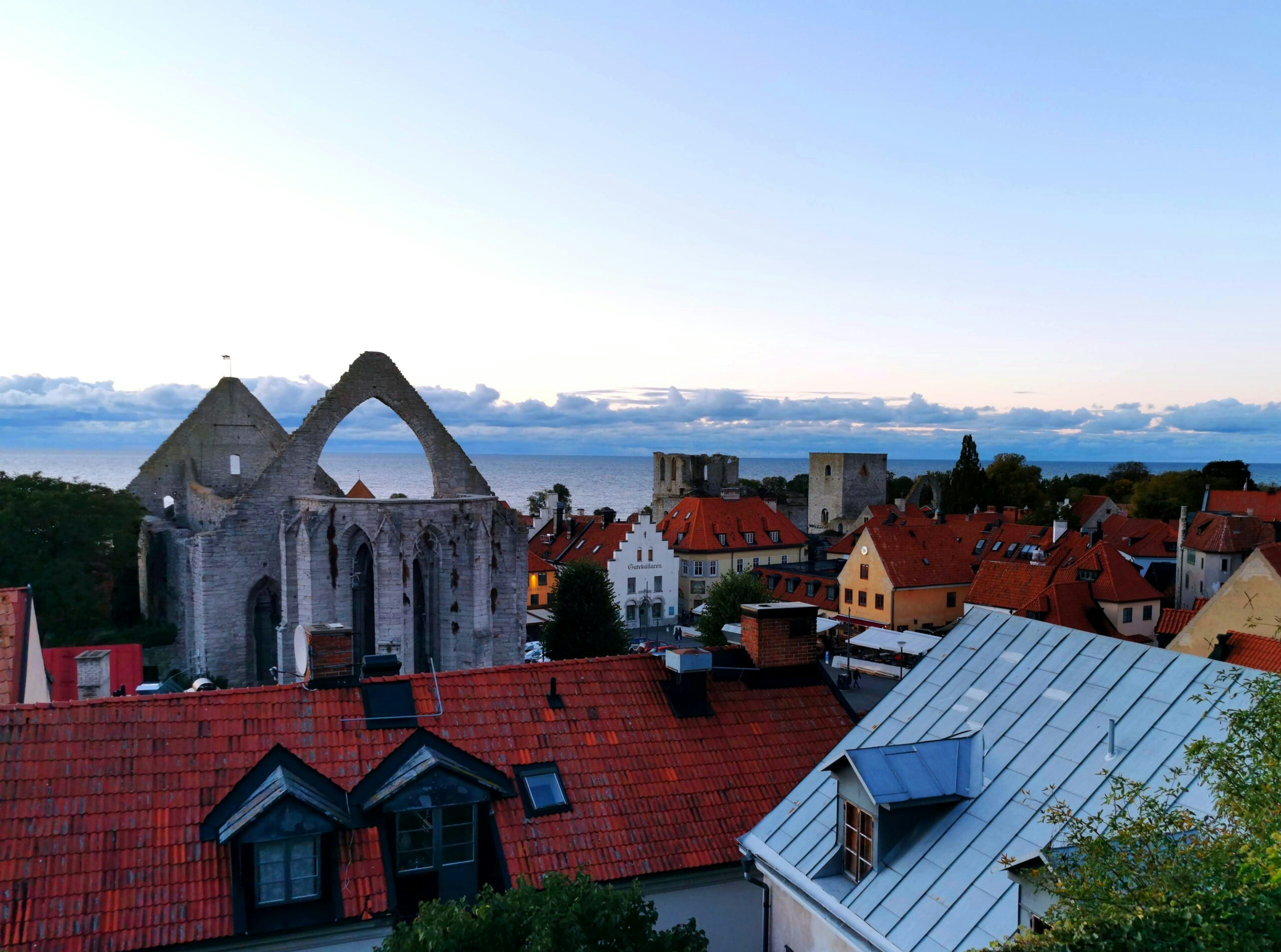 Utsikt från trappgatan över Stora torget i skymningen. Härifrån ser man bland annat Sankta Karins kyrkoruin, Gutekällaren och Drottens ruin med Östersjön i bakgrunden.