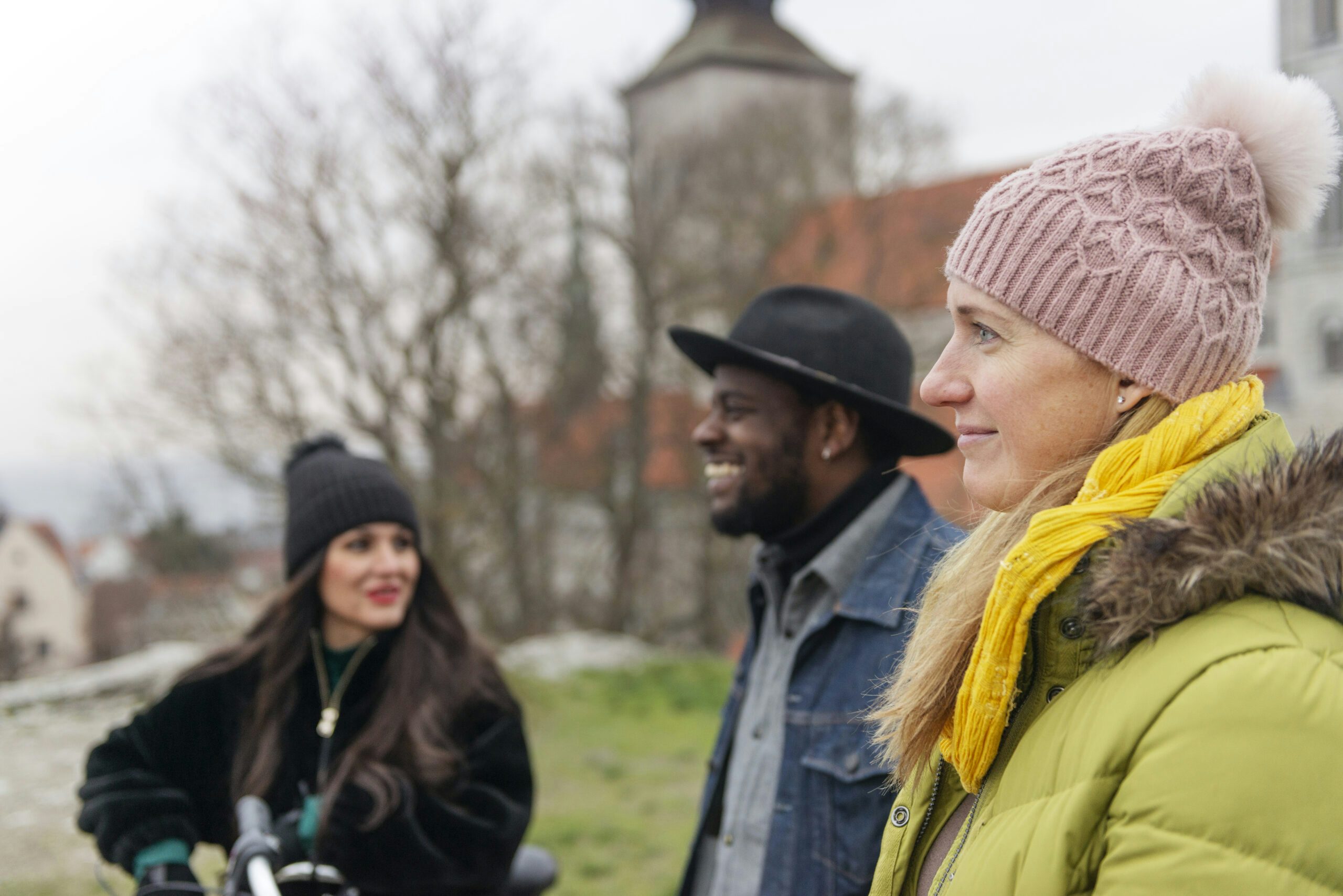 Två tjejer och en kille samtalar på klinten i Visby, i bakgrunden syns domkyrkans siluett.